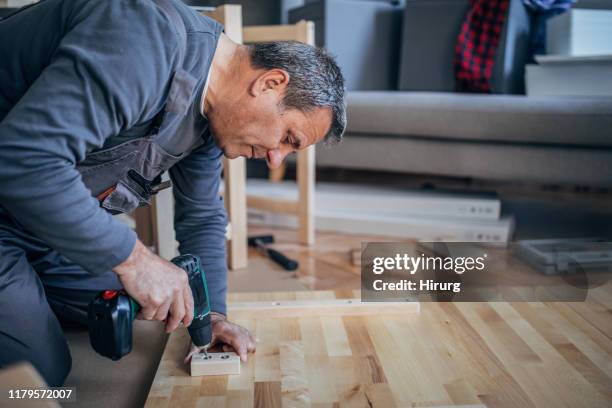 o homem está montando a mobília com broca - kit modelo - fotografias e filmes do acervo