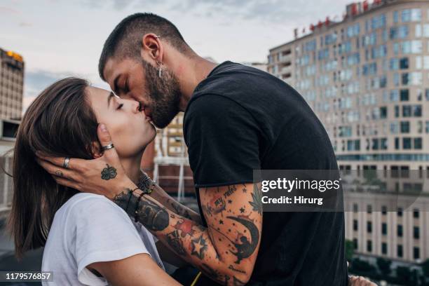 pareja joven besándose - alluring fotografías e imágenes de stock