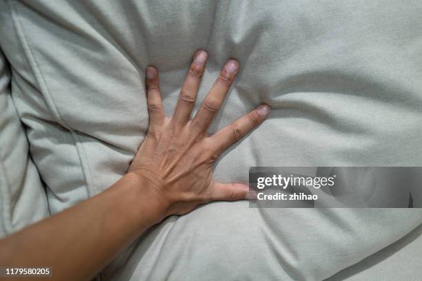 the human hand pressed hard on the pillow - pillow stock pictures, royalty-free photos & images