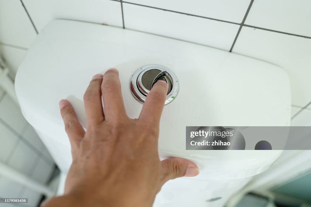 Human hand flushing toilet