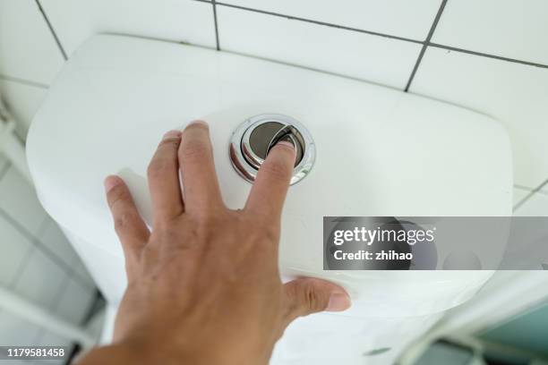 human hand flushing toilet - flushing stock pictures, royalty-free photos & images