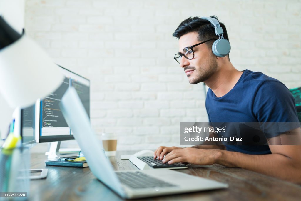 Latin Freelance Coding Expert Using Computer At Desk