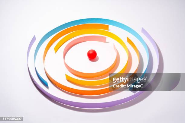 abstract paper wall surrounding red sphere - circondare foto e immagini stock