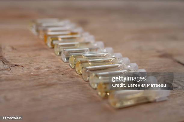 group of small glass bottles on wooden background. perfume testers or chemical samples. - assembly kit stock pictures, royalty-free photos & images