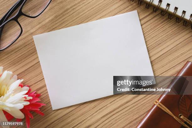 close up of white paper card on wood desk - blank paper on table stock pictures, royalty-free photos & images