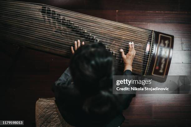 close up of hands of a chinese woman playing a zither, a traditional chinese musical instrument - zither stock pictures, royalty-free photos & images