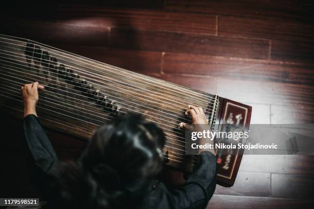 close up of hands of a chinese woman playing a zither, a traditional chinese musical instrument - zither stock pictures, royalty-free photos & images