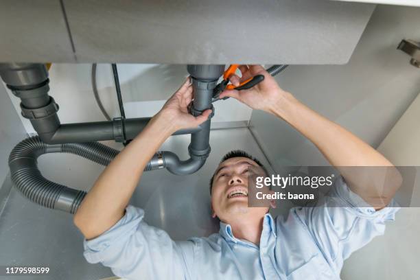 man repareren sink pijp in de keuken - kitchen straighten stockfoto's en -beelden