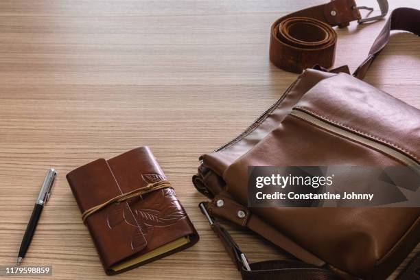 still life of laptop and notebook on wooden work desk - brown purse stock-fotos und bilder