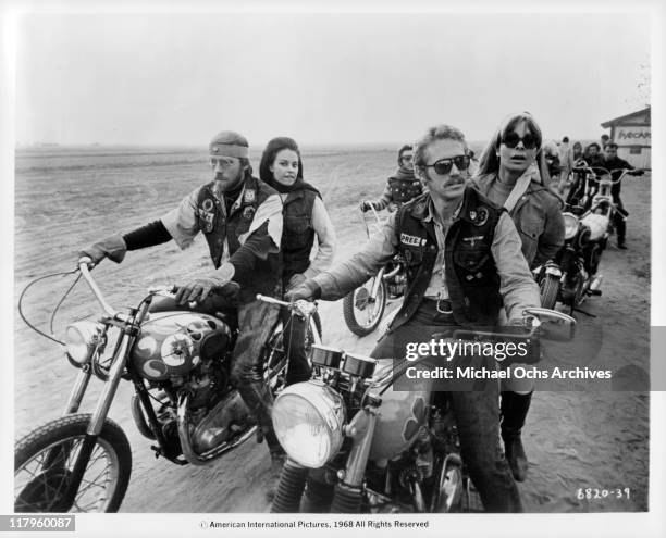 Ted Markland and Tom Sternwith riding motocycles with Suzy Walters and Arlene Martel sitting behind them in a scene from the film 'Angels from Hell',...