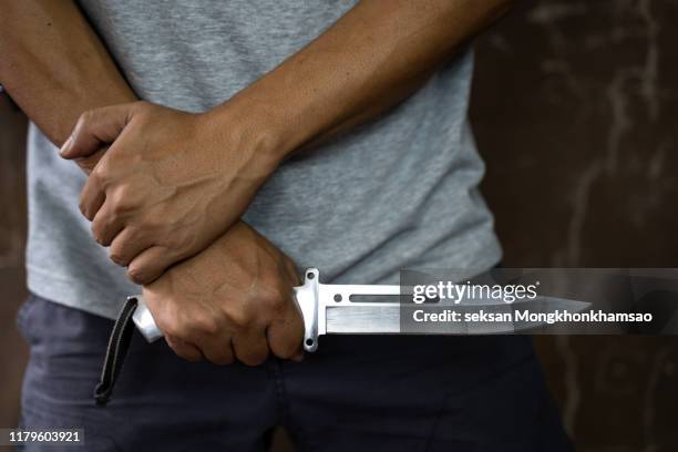 criminal or bandit holding a knife. - matar imagens e fotografias de stock