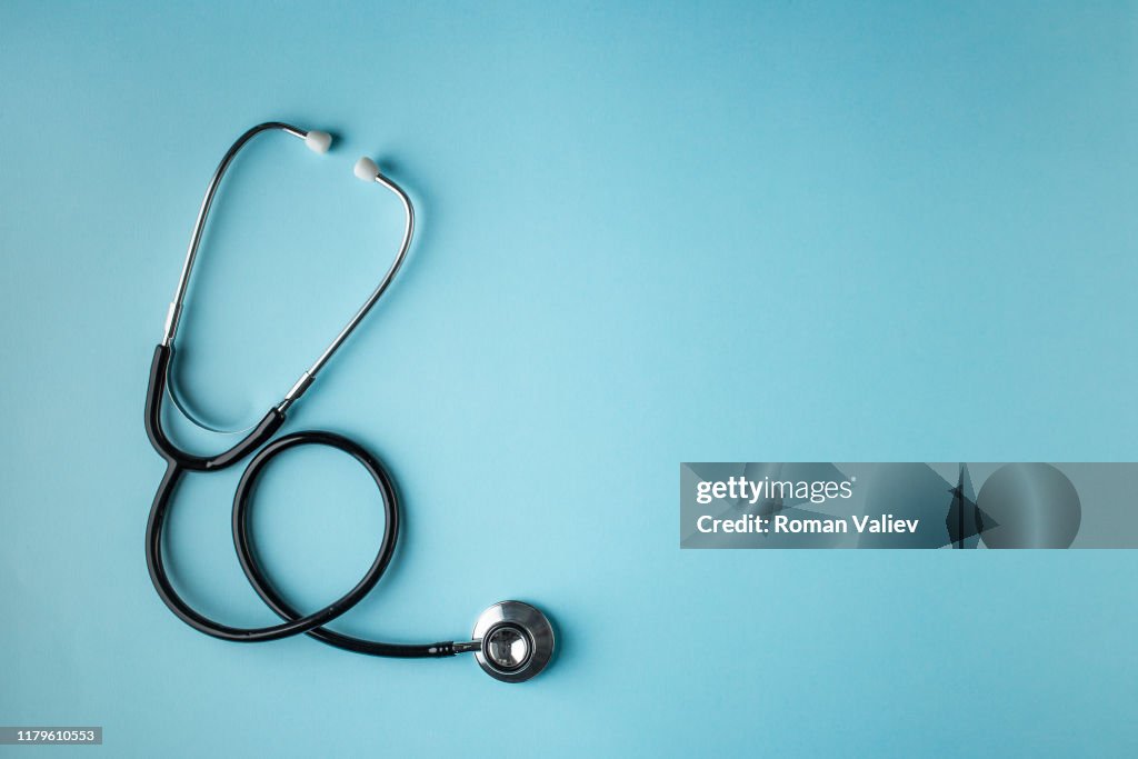 Black stethoscope on blue background