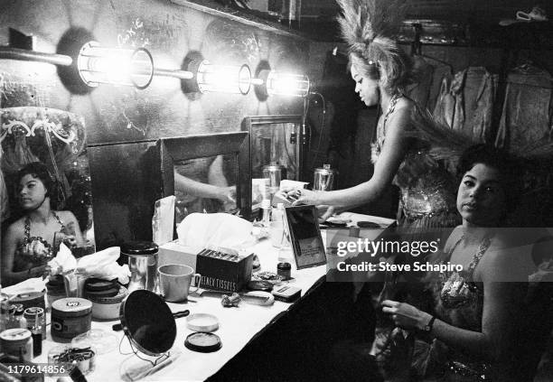 Unidentified dancers, already in costume, make last minute adjustments backstage at a make-up table backstage in the Apollo Theater, New York, New...