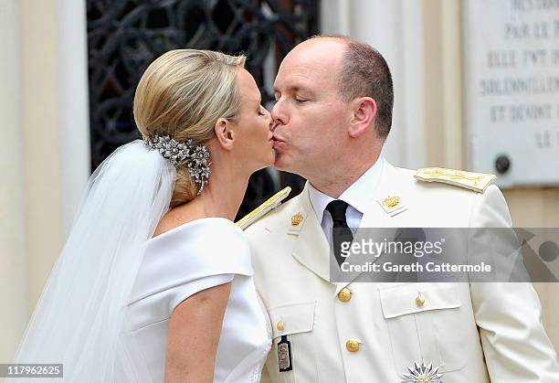 Princess Charlene of Monaco and Prince Albert II of Monaco kiss as they leave Sainte Devote church after their religious wedding ceremony at the...
