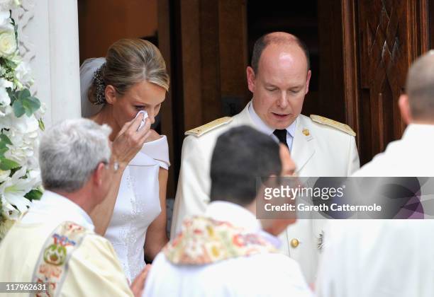 Princess Charlene of Monaco wipes away a tear as she and Prince Albert II of Monaco leave Sainte Devote church after their religious wedding ceremony...