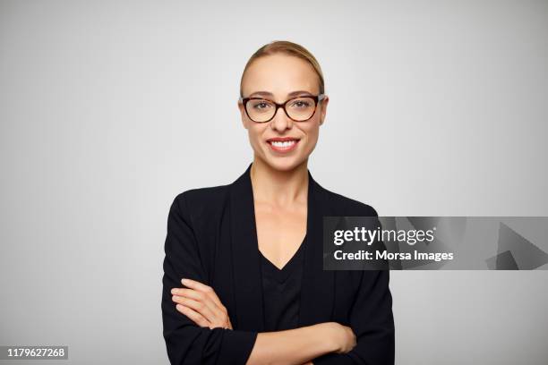 smiling young businesswoman with arms crossed - black woman arms crossed stock pictures, royalty-free photos & images