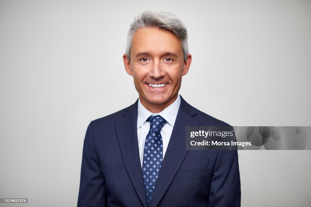 Smiling mature male leader wearing navy blue suit