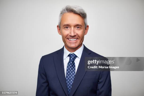 smiling mature male leader wearing navy blue suit - fato imagens e fotografias de stock