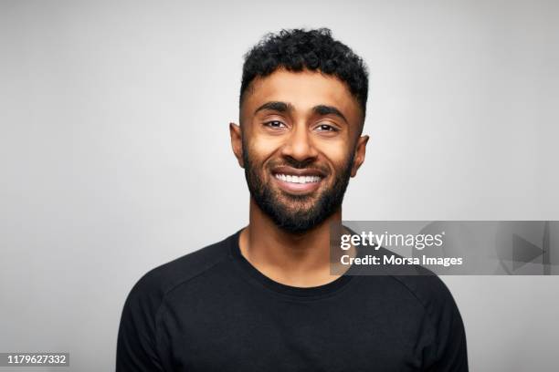 bearded businessman against gray background - black tshirt stock-fotos und bilder