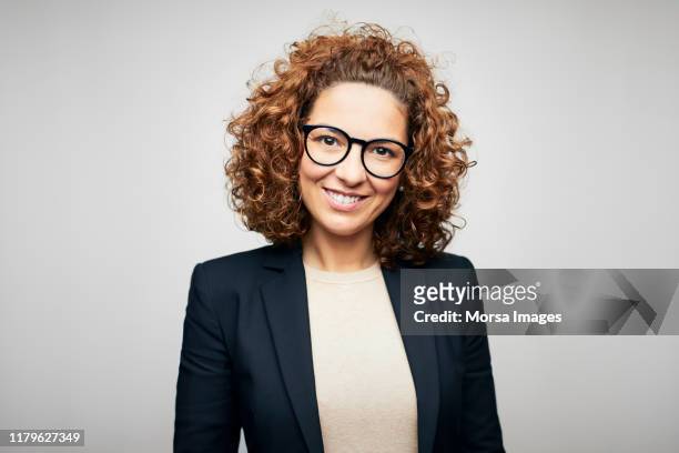 smiling female brunette ceo wearing eyeglasses - blue blazer stock pictures, royalty-free photos & images