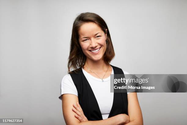 cheerful businesswoman with arms crossed - métier du design photos et images de collection