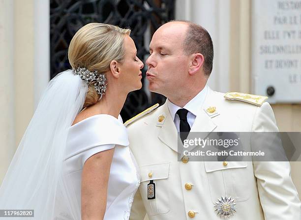 Princess Charlene of Monaco and Prince Albert II of Monaco kiss as they leave Sainte Devote church after their religious wedding ceremony at the...