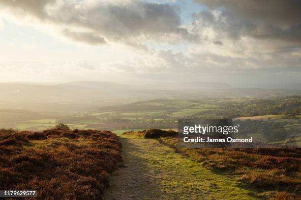 bridleway on hilltop with coutryside views below at sunset. - scena rurale foto e immagini stock