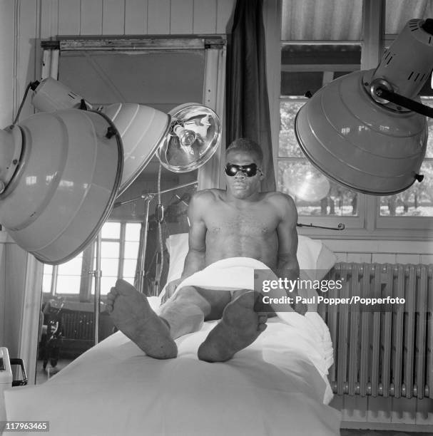 Weightlifter Rodney Wilkes, from Trinidad and Tobago, relaxes under a sun lamp at the Olympic village in Richmond, Surrey, during the London...