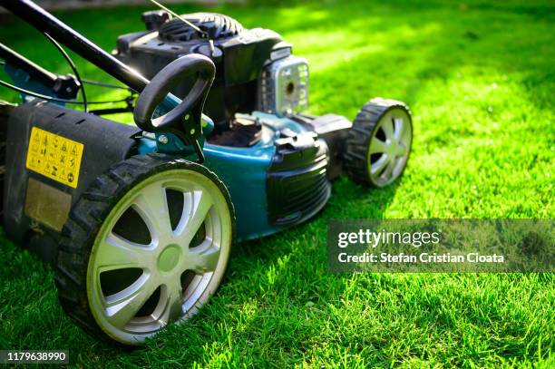 lawn mower on green grass in a sunny day. - grasmaaier stockfoto's en -beelden