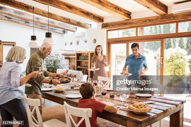 famille multigénérationnelle se préparant pour le déjeuner à la maison - réunion de famille photos et images de collection