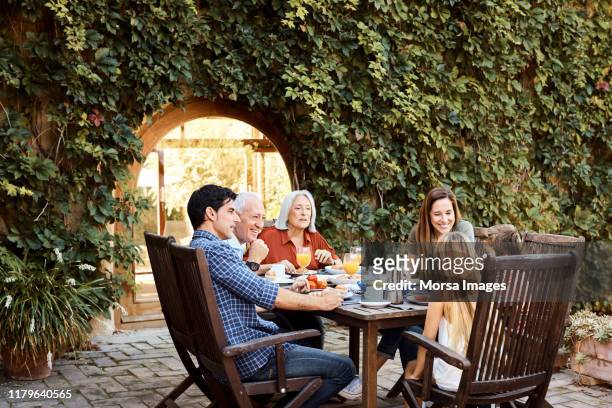 famiglia multi-generazione che colazione in cortile - garden furniture foto e immagini stock