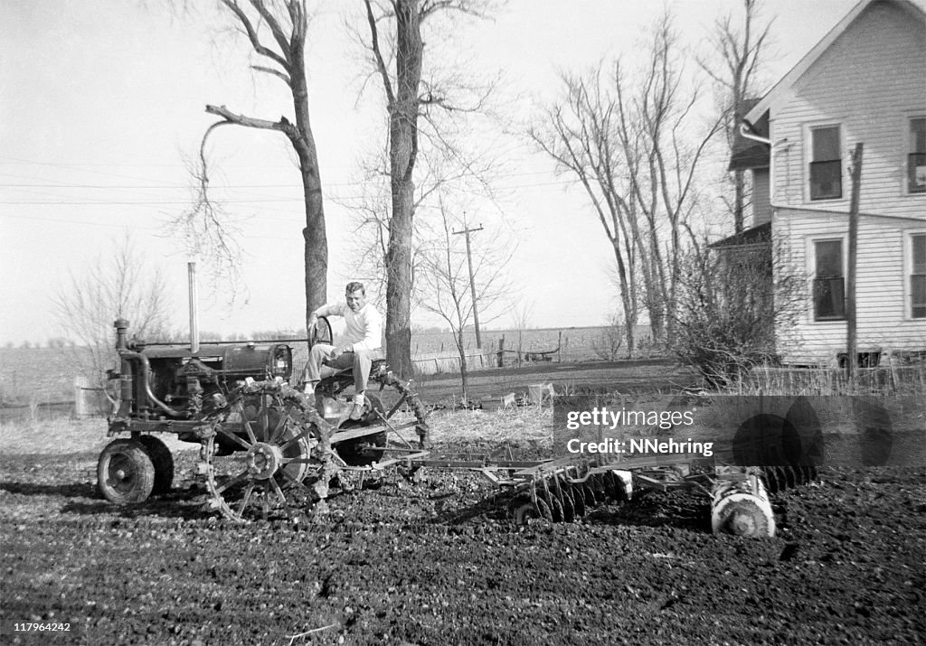 Man on tractor disking 1941, retro