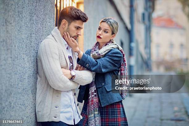 donna sta consolando il suo fidanzato imbronciato per strada - diverbio foto e immagini stock