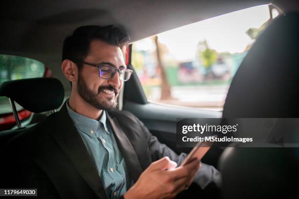 businessman in the taxi, using a mobile phone - taxi imagens e fotografias de stock