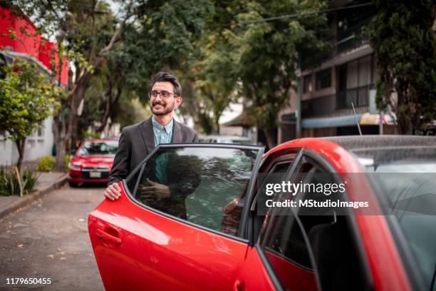 homme d'affaires ouvrant la porte de voiture - entering photos et images de collection