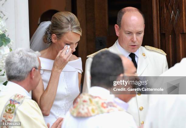 Princess Charlene of Monaco wipes away a tear as she and Prince Albert II of Monaco leave Sainte Devote church after their religious wedding ceremony...