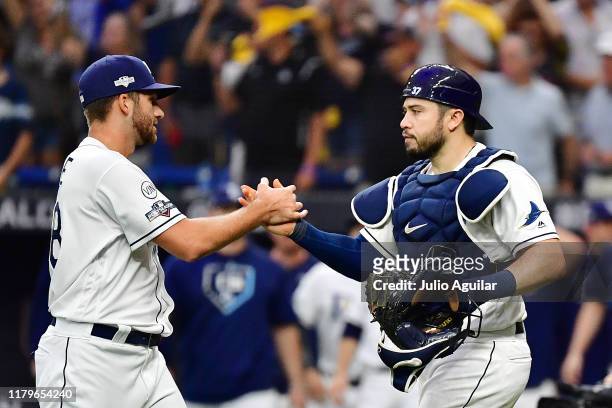 Colin Poche of the Tampa Bay Rays celebrates with Travis d'Arnaud after defeating the Houston Astros 10-3 in Game Three of the American League...