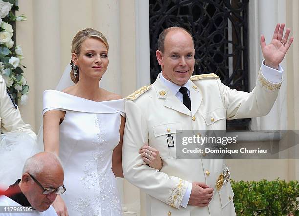 Princess Charlene of Monaco and Prince Albert II of Monaco wave to the crowds as they leave Sainte Devote church after the religious ceremony of...