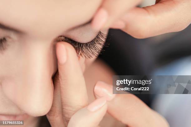 makeup artist applying false eyelash - eyelash extensions stock pictures, royalty-free photos & images