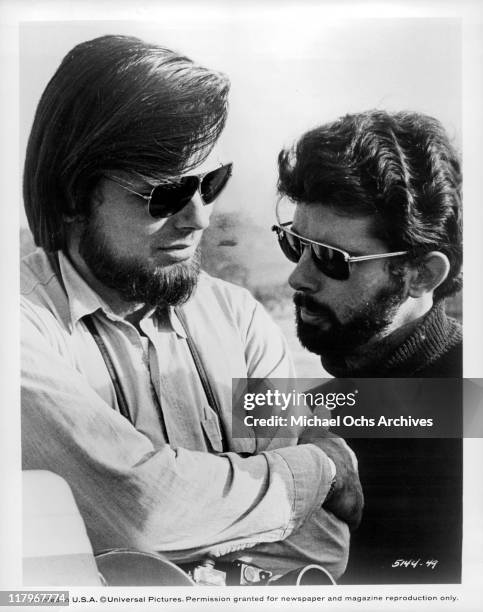 Director George Lucas and co-producer Gary Kurtz wearing sunglasses on the sets of the film 'American Graffiti', 1973.