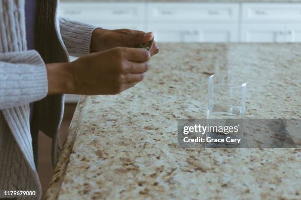 cropped view of woman removing pill from blister pack - ibuprofen stock-fotos und bilder