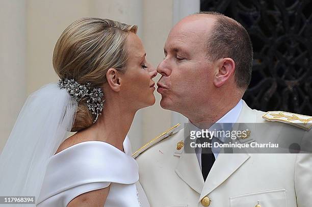 Princess Charlene of Monaco and Prince Albert II of Monaco kiss as they leave Sainte Devote church after the religious ceremony of their Royal...