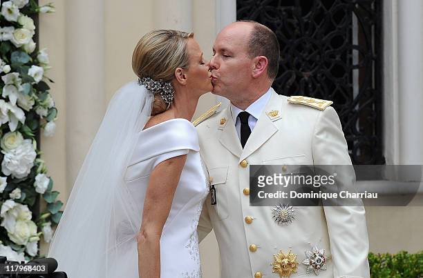 Princess Charlene of Monaco and Prince Albert II of Monaco kiss as they leave Sainte Devote church after the religious ceremony of their Royal...