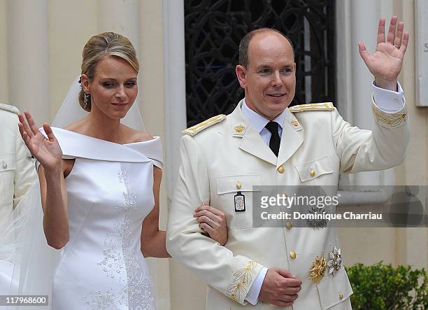 Princess Charlene of Monaco and Prince Albert II of Monaco wave to the crowds as they leave Sainte Devote church after the religious ceremony of...