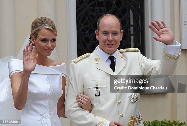 Princess Charlene of Monaco and Prince Albert II of Monaco wave to the crowds as they leave Sainte Devote church after the religious ceremony of...