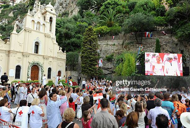 Crowds watch the big screen of the the religious wedding ceremony of Prince Albert II of Monaco and Princess Charlene of Monaco at the Sainte Devote...