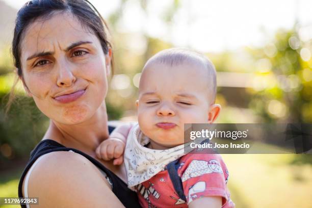 mother and toddler son having fun in the garden - bébé grimace photos et images de collection