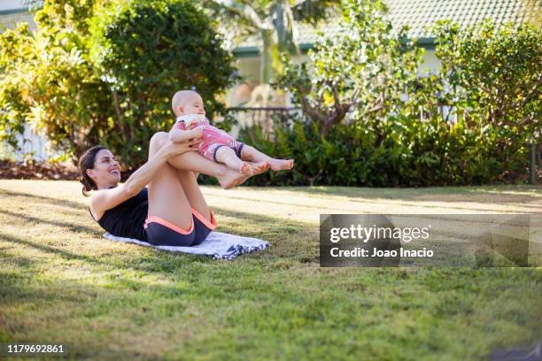 mother with toddler son exercising in the garden - thisisaustralia stock-fotos und bilder