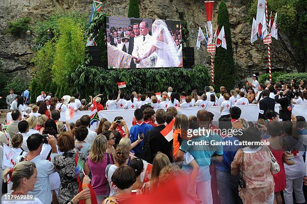 Crowds watch the big screen of the the religious wedding ceremony of Prince Albert II of Monaco and Princess Charlene of Monaco at the Sainte Devote...