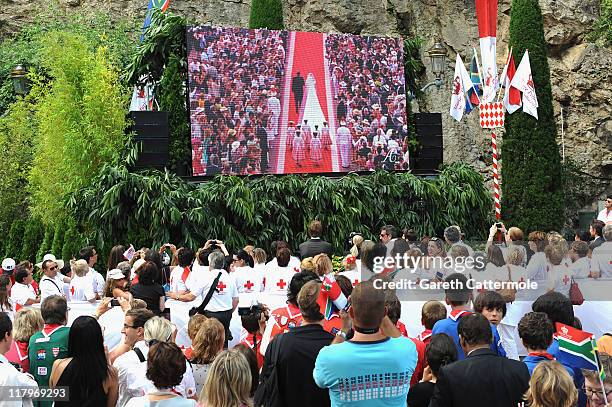 Crowds watch the big screen of the the religious wedding ceremony of Prince Albert II of Monaco and Princess Charlene of Monaco at the Sainte Devote...